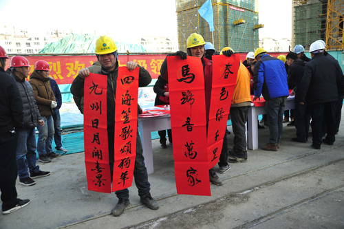 工人师傅们展示刚刚拿到手的新春对联活动现场宗俊  报道
